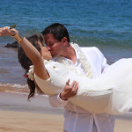 Couple celebrating their wedding with a kiss on a Maui beach.